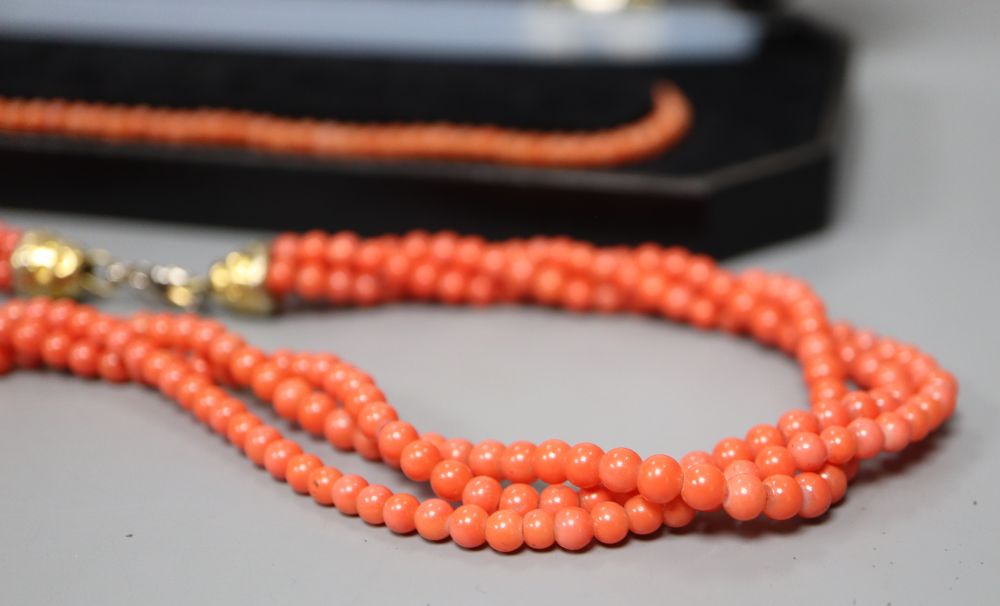 A white metal and carved coral set oval dress ring and three assorted necklaces.